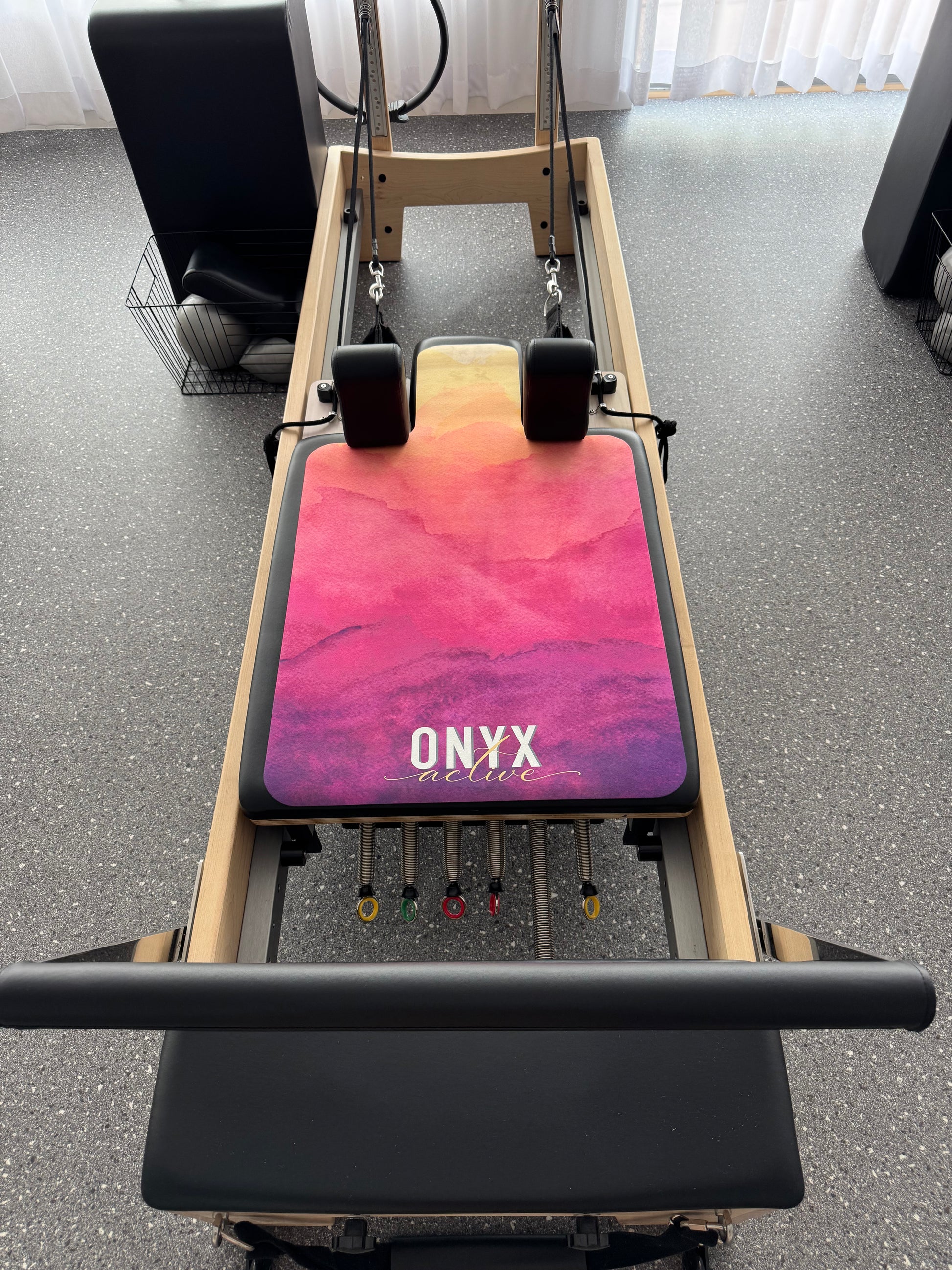 A purple, sunset-themed design Onyx Active reformer Pilates mat with a luxurious suede top and a 3mm thick rubber base.